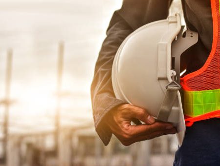 Technician holding white hat safety hard hat sunlight background