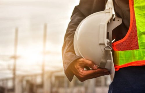 Technician holding white hat safety hard hat sunlight background Technician holding white hat safety hard hat sunlight background